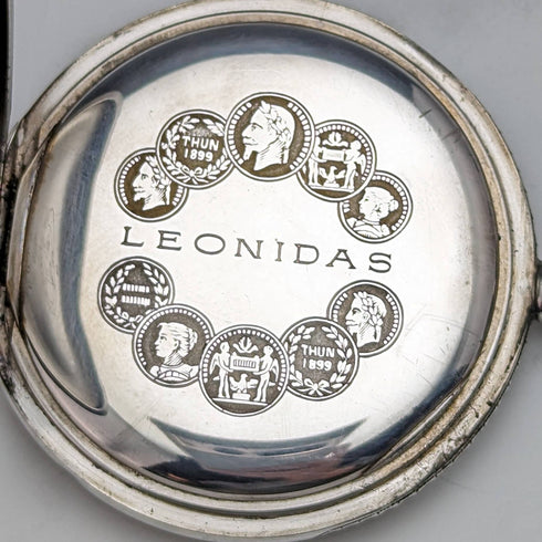 Reloj de bolsillo antiguo Leonidas de fabricación suiza, con caja de plata tipo saboneta grabada con motivos florales, en buen estado de funcionamiento.